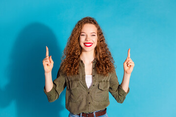 Sticker - Photo of nice young lady direct fingers up empty space wear khaki shirt isolated on teal color background