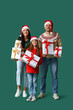 © Pixel-Shot - Happy family with Christmas presents on green background