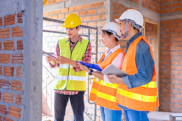 a young foreman explaining electrical wiring system to team experienced inspector of real estate home project while having inspection on site work in the building under construction