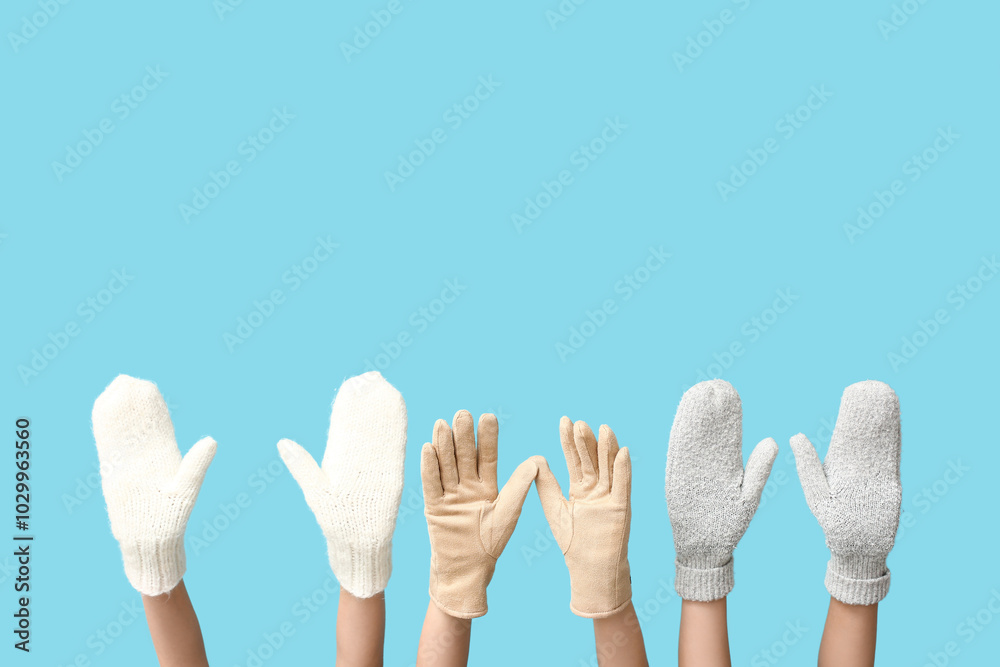 Hands in warm gloves and mittens on blue background