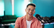 © Flashizzle/peopleimages.com - Live streaming, man and happy as radio presenter with microphone, talk show or entertainment. Male person, content creator and podcast host in studio for recording audio or social media on portrait