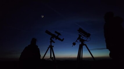 Wall Mural - amateur astronomers looking at the evening skies, observing planets, stars, moon and other celestial
