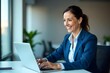 © NISHAN'S STUDIO - Happy busy mature business woman entrepreneur in office using laptop at work, smiling professional middle aged female company executive manager working looking at computer at workplace
