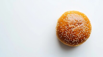 Golden-brown hamburger bun with sesame seeds, photographed from above on a white background, showcasing its freshly baked appearance. 