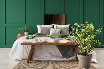 Canvas Print - Interior of stylish bedroom with cozy bed, houseplant and wooden bedside bench