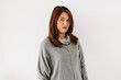 © Suthida - Funny face of asian Thai woman wear sweater get confused, scratching hand, resting hands on waist and looking at camera, isolated over white background wall.