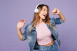 © ViDi Studio - Young woman she wear denim jacket violet top casual clothes listen to music in headphones sing song in microphone isolated on plain pastel light purple background studio portrait. Lifestyle concept.