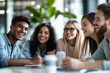 © Sitthikorn - Diverse group of smiling young businesspeople having a meeting together around a table in a modern office.