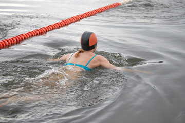 Wall Mural - A woman is swimming in a pool with a red rope around the pool