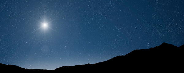Wall Mural - a christmas star shines at night over the mountains of bethlehem