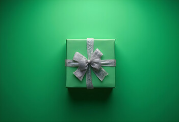 beautifully wrapped green gift box with silver ribbon sits against vibrant green background, creating cheerful and festive atmosphere