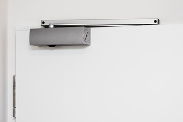 Door Closer. Modern Adjustable Overhead Door Closers on White Wood Door AdjustableClosing Speed, Locking Speed. Copy space.