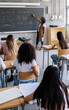 © Xavier Lorenzo - Diverse high school students listening to female teacher in classroom while she is explaining the lesson. Education concept