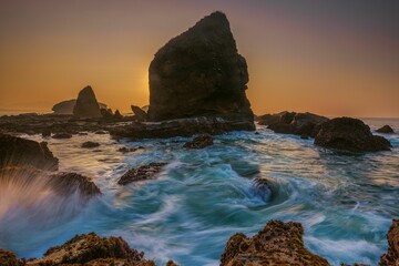 Dramatic coastal seascape with rugged rocks at sunset.