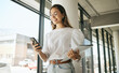 © Flashizzle/peopleimages.com - Business woman, folder and smile with phone in office for text message, checking notifications and networking. Professional, employee and happy with smartphone at workplace for communication or email