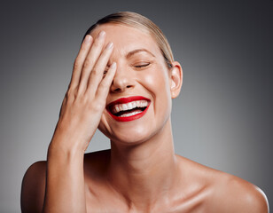 Laughing, lipstick or skincare of mature woman in studio for glow, results or funny joke on gray background. Face, elegant or happy model with beauty cosmetics for confidence, silly humor or wellness