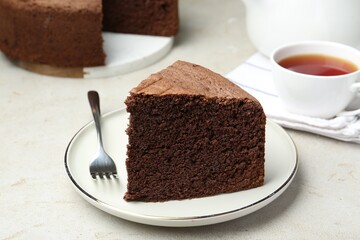 Wall Mural - Piece of tasty chocolate sponge cake served on light table, closeup
