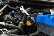 © zphoto83 - A mechanic using a wrench to perform maintenance on a car engine during a service session in an automotive garage
