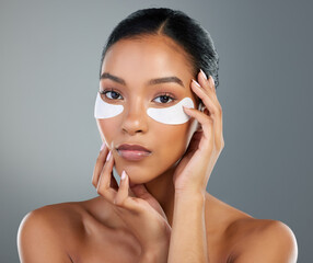 Poster - Woman, skincare and eye patch in studio portrait with process, test and wellness by background. Girl, model and person with cosmetics, dermatology and pads with facial transformation in Brazil