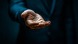 © Olha Havelia - Close-up of a hand reaching or giving something on a dark blue background, a business concept for showcasing a product or service. A businessman offering an open palm, ready to gra