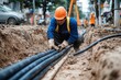 © Thanapong - A construction worker installing underground electrical cables, highlighting the critical infrastructure needed for power distribution and urban development in modern cities.