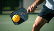 © Darr.di - Close up action of a pickleball game, player about to hit an pickleball with a paddle or racket. The pickleball is in sharp focus in the foreground