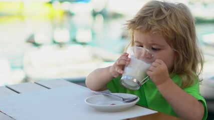 Wall Mural - Baby eats with a spoon. Child have a meal. Hungry little kid eating kids food. Baby porridge. Little baby eating healthy food of dishes. A Little baby eating her dinner. Kids facial expression.