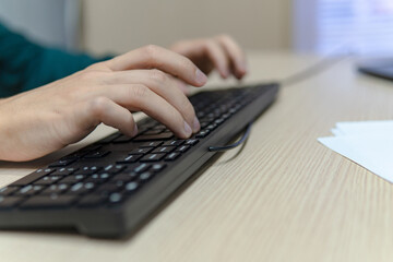 Close up businessman hands using a computer in the office, side view, typing the keyboard, business concept