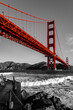 © ON-Photography - Wide-angle shot of the world-famous Golden Gate Bridge in San Francisco, California. Black and white landscape and red steel construction of the suspension bridge over the stormy waters of the bay.