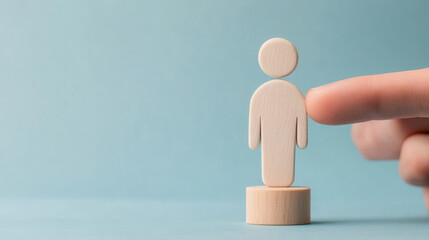 hand gently touches wooden figure representing person, symbolizing guidance and support in professional setting. This conveys inspiration and leadership