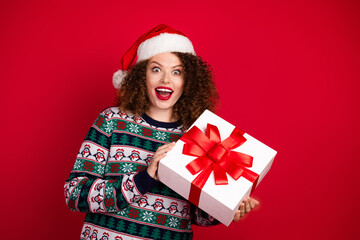 Portrait of nice young girl hold giftbox empty space wear new year xmas sweater isolated on red color background