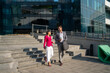 © Nenad - Business people, walking and travel in city with discussion on morning commute, partnership and happy. Employees, man and woman with conversation, collaboration and networking outdoor in urban town