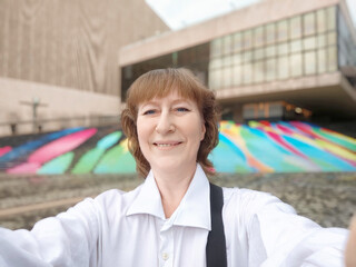 A middle-aged woman who is a tourist and blogger takes selfies in a youth space in Hong Kong