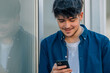 © carballo - young man or boy looking at his mobile phone on the street