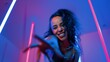 © InfiniteFlow - Low angle camera of hispanic dancer looking at camera and dancing to city pop music. Professional attractive hipster moving to hip hop song with purple led or neon light. Stylish cloth. Regalement.