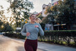 © Zamrznuti tonovi - Young woman running in the city on a sunny day