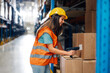 © Zamrznuti tonovi - Female warehouse worker scanning barcodes on boxes
