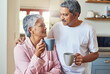 © TamJam/peopleimages.com - Love, elderly couple and coffee in kitchen with hug, affection and smile with care for happy marriage. Senior people, morning and embrace in home for commitment, support and comfort in retirement