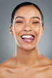 © DavisShared/peopleimages.com - Woman, tongue out and studio for oral health, smile and teeth whitening results on gray background. Female person, cosmetics and braces or veneers transformation, treatment and dental confidence