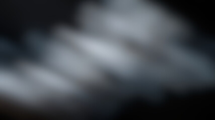 A blurred image with a gradient of dark colors, including black, gray, and white, with a diagonal pattern
