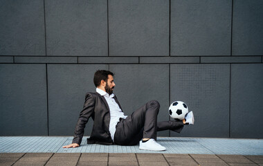 Businessman playing with a soccer ball and making freestyle tricks