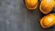©  Jovaduplex - Aerial view of two yellow hard hats placed on a weathered concrete surface, symbolizing safety and preparedness in industrial settings, focusing on teamwork.
