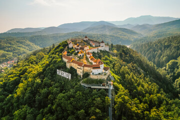 Aerial view of Rasnov Fortress and Rasnov city and forest around in Brasov, Transylvania, Romania