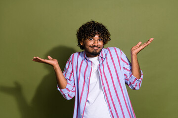 Poster - Portrait photo of indifferent arabian businessman in striped casual shirt and eyeglass isolated on khaki color background