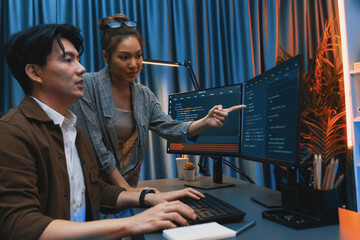 IT developers discussing with point to intelligent website development coder system running data online two screens information technology at neon light room at modern office. Infobahn.