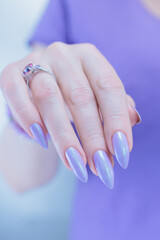 Wall Mural - Female hand with long nails and a lilac blue nail polish