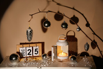 Lantern with Christmas balls and calendar on table in dark room