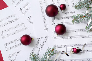 Music note sheets with Christmas decor on red background