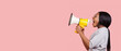 © Prostock-studio - Making announcement. Black woman shouting in megaphone towards copy space over pink background, panorama