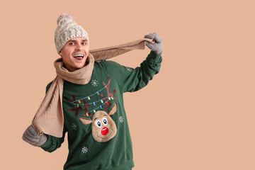 Poster - Young man in Christmas sweater on beige background